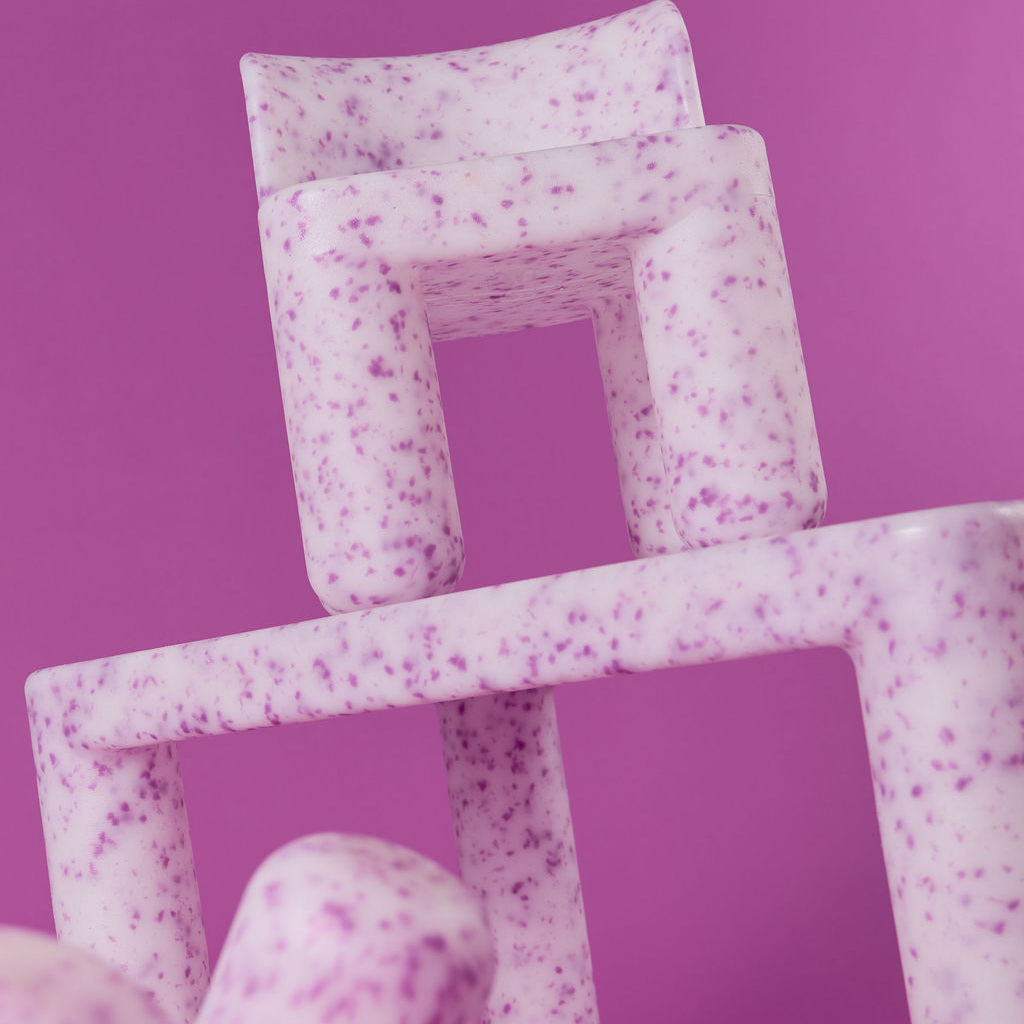 Stack of pink textured boxes on a purple background