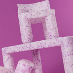 Stack of pink textured boxes on a purple background
