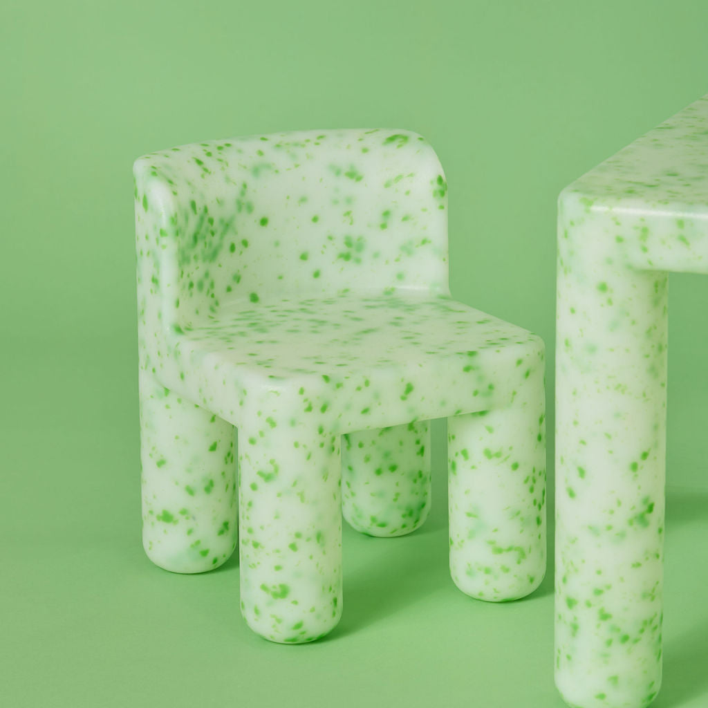 Green textured chair and table set against a green background
