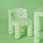 Green textured chair and table set against a green background