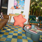 Red and Pink Stripped Star Bean bag standing up against a console unit in a colourful retro electric living area