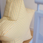 Chair with striped yellow and white cover against a plain wall