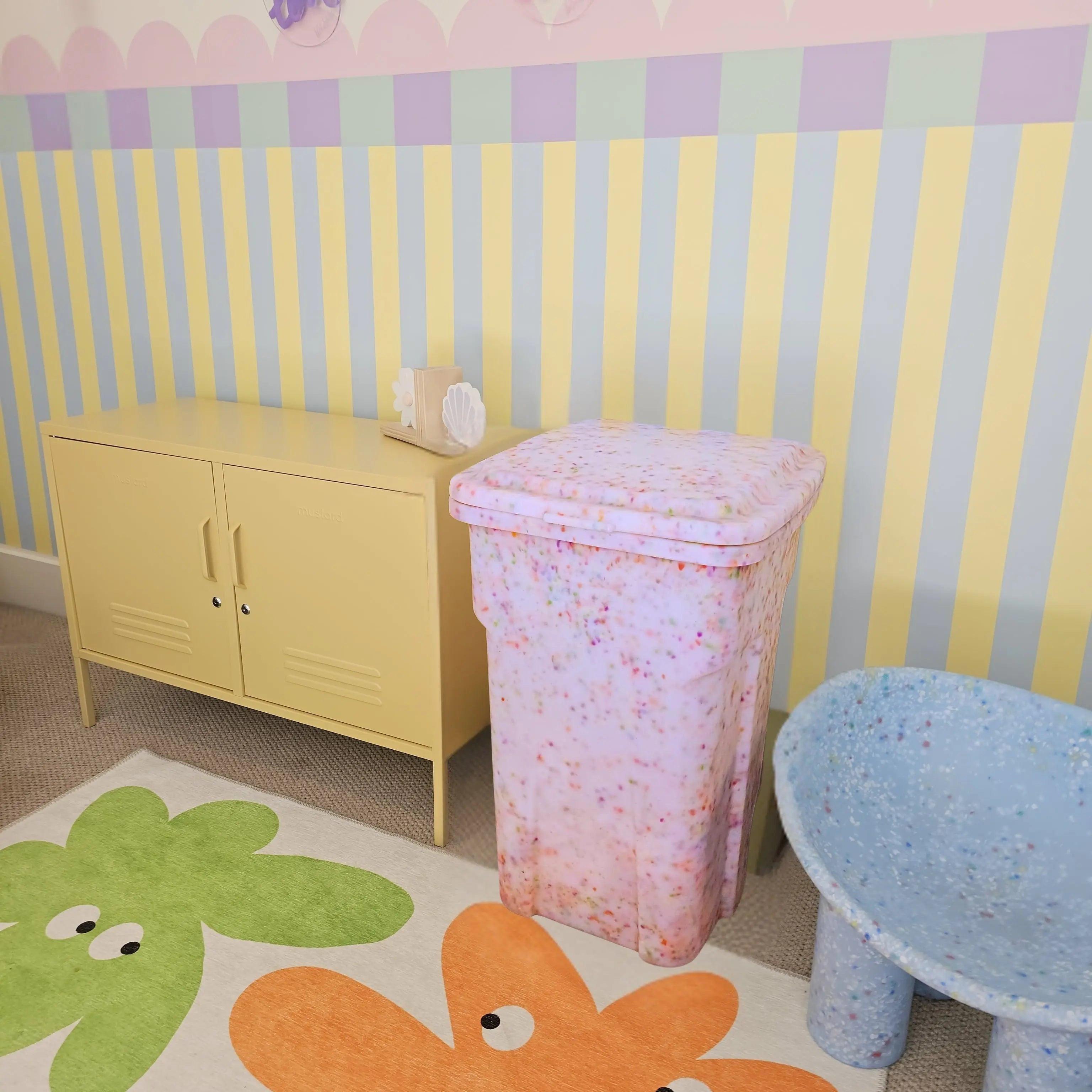 Children's room with colorful wallpaper, furniture, and a rug with floral designs.