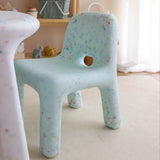 Children's chair with colorful pattern in a room with toys and furniture.
