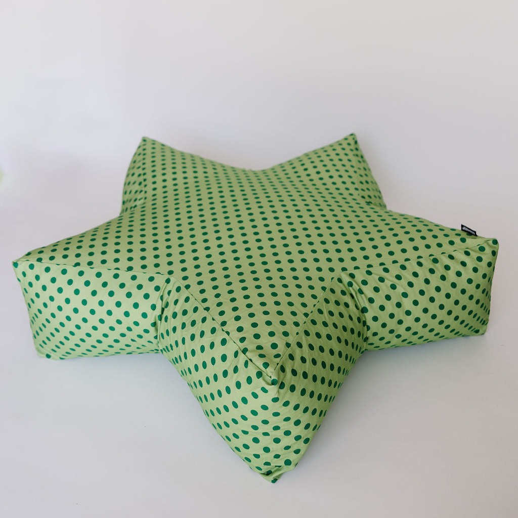 A five-pointed star-shaped floor cushion with a green and white polka dot pattern, photographed against a plain white background.