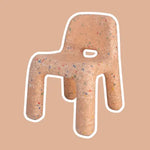 Peach Confetti Chair with a speckled pattern on a beige background