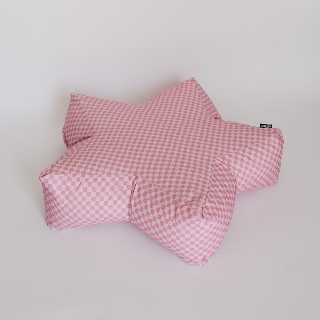 A star-shaped plush pillow with a pink and white gingham checkered pattern, photographed against a plain off-white background.