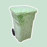 Green trash bin with a textured surface on a light green background