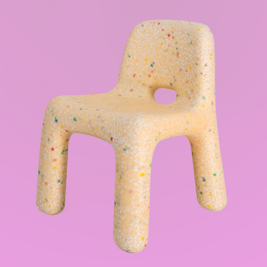 Toy chair with colorful specks on a pink background
