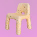 Toy chair with colorful specks on a pink background