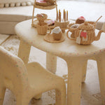 Children's plastic chair with wicker baskets and toys on a patterned rug