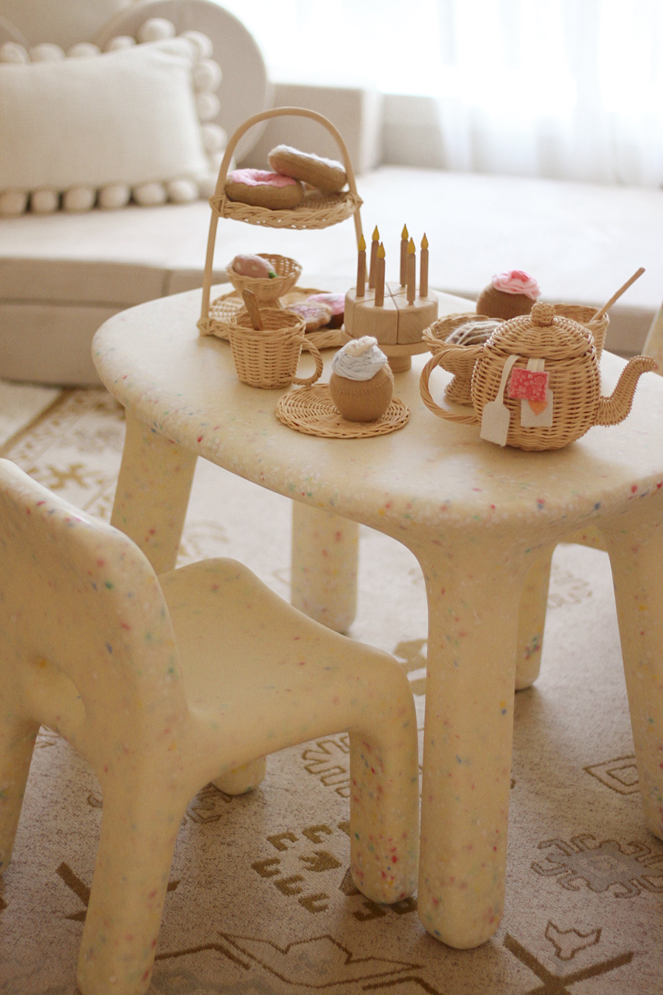 Children's plastic chair with wicker baskets and toys on a patterned rug