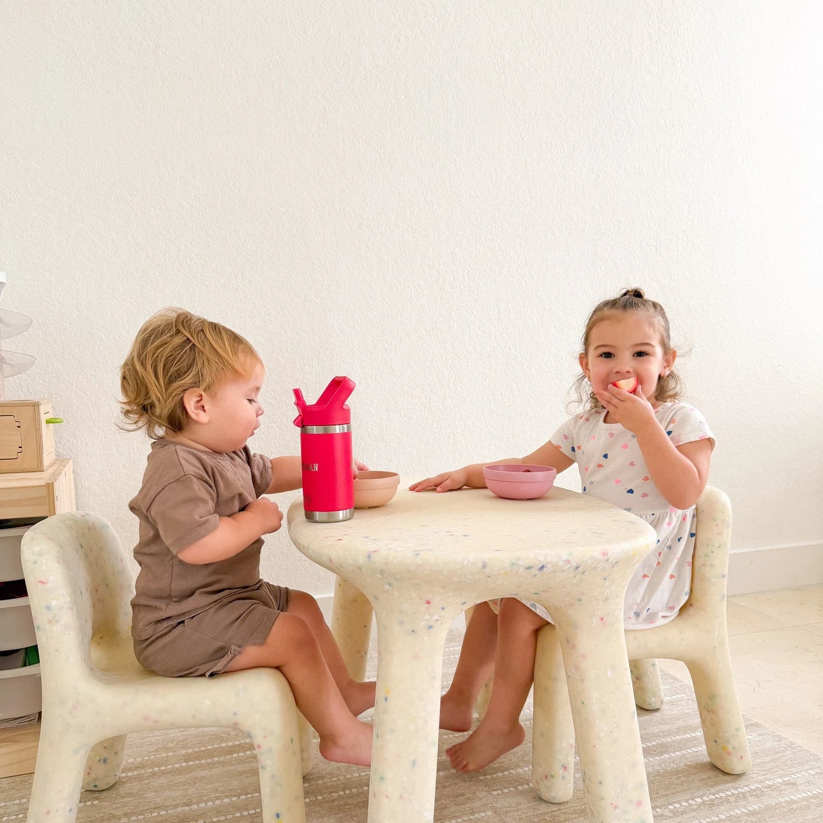 Two children sitting at a Confetti table and chairs set